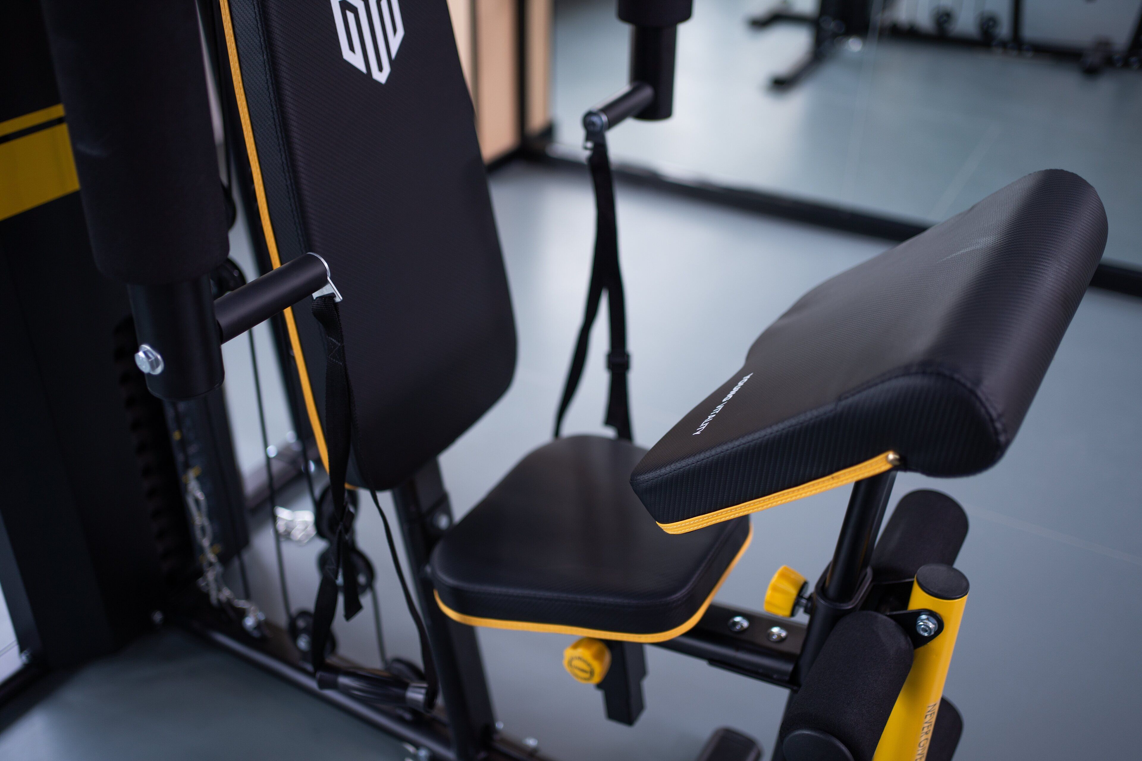 A stationary exercise bike with a black seat and yellow accents, a control panel, and a branded logo on the backrest.