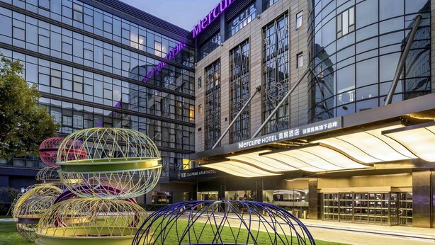 Ein modernes Hotel mit Glasfassade und einer Neonreklame.