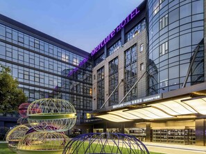 Un hôtel moderne doté d'une façade en verre et d'une enseigne lumineuse au néon.