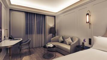 Una habitación de hotel moderna con escritorio, sofá, mesa de centro y cama.