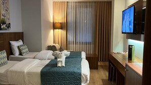 A hotel room with a bed, a desk, a television, and a window with curtains. - The White Orient Hotel (Istanbul)