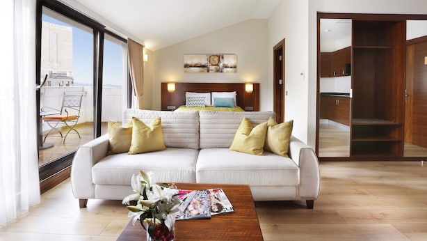 A modern living room with a sofa, coffee table, and a bed with a headboard. - The White Orient Hotel (Istanbul)