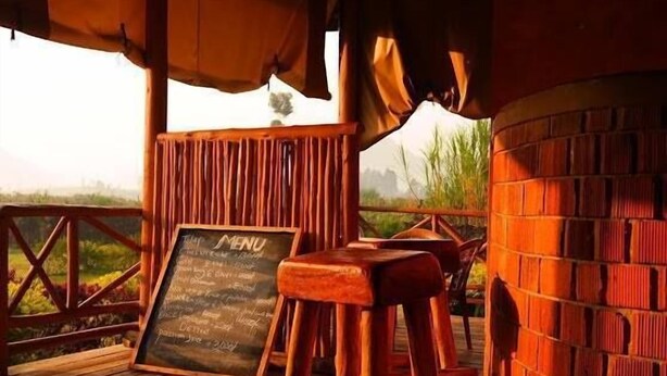 A wooden deck with a brick wall and a chalkboard menu. - Lake Chahafi  Resort (Kisoro)