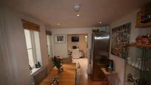 Cocina compacta con refrigerador, microondas y zona de comedor.