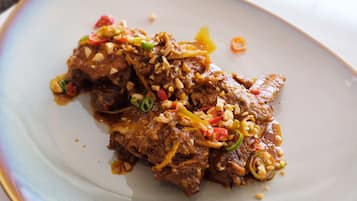 A plate of beef with vegetables and nuts.