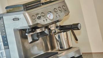 A Breville espresso machine with a digital display, control panel, and steam wand.