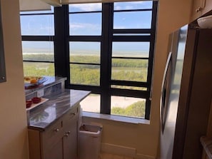 Una cocina con un ventanal que ofrece vistas a un paisaje llano.