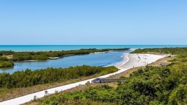 A coastal landscape with a beach, a waterway, and dense greenery. - 2/2 condo, with fantastic views of the beach (Marco Island)