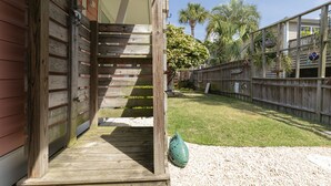 A wooden staircase leading to a covered porch with a decorative fish sculpture at the bottom.