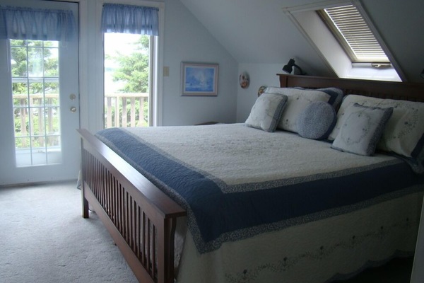 The master bedroom has a king size bed and a private deck with a beautiful view of the water.