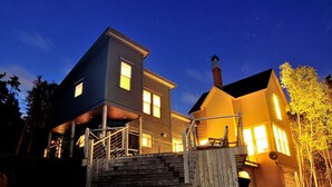Une maison à deux étages avec un porche et un escalier menant à l’entrée.