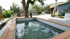 Une piscine rectangulaire entourée d’une terrasse en bois.