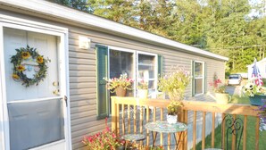 A wooden deck with a railing, a door with a welcome wreath, and several potted plants. - whole 🏠! 10% off 7 nts or more, 15% off 28 nts or more (Bethlehem)