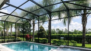 A swimming pool with a hot tub, surrounded by a glass enclosure and palm trees. - Free Shuttle,Official Encore Water Park,XBOX,Movie,Games,Cage,Pool/Spa,Star Wars (Kissimmee)