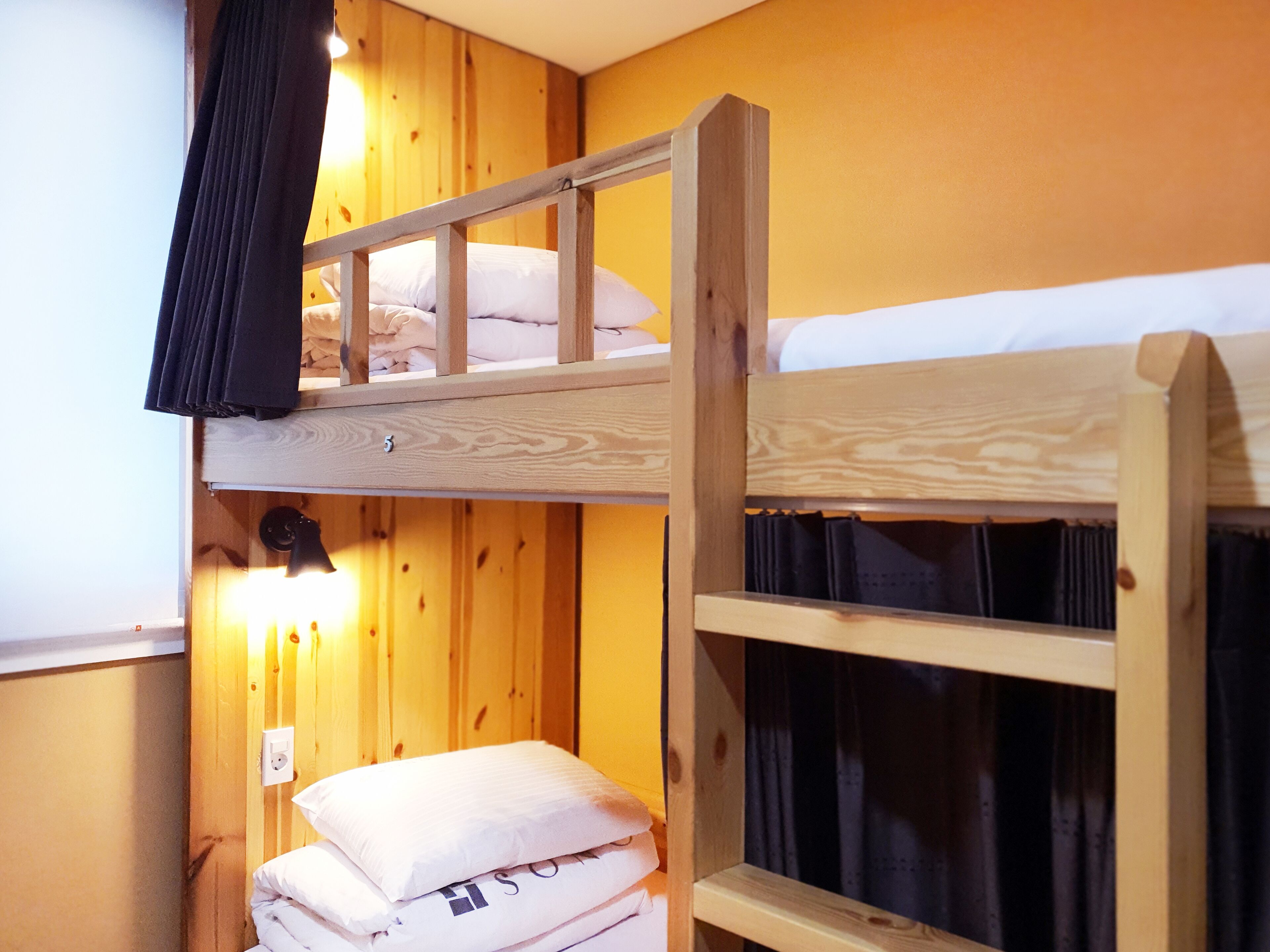 A bunk bed room with wooden walls and a single light fixture.