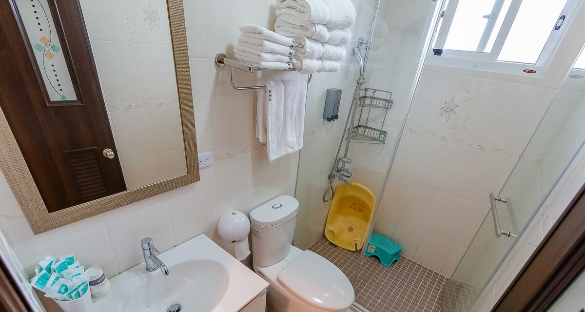 Baño con lavabo, inodoro y zona de ducha.