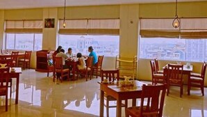 Un comedor amplio con techos altos y ventanas grandes que ofrecen vista a la ciudad.
