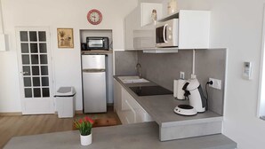 A compact kitchen with a refrigerator, microwave, sink, and coffee machine. - Villa-type ground floor apartment with spacious private terrace - sleeps 4 (Agde)