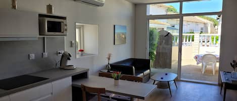 A modern kitchen with a microwave, coffee maker, and a small dining area with a table and chairs.