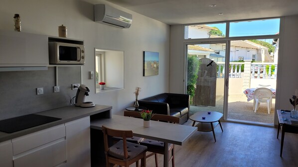 A modern kitchen with a microwave, coffee maker, and a small dining area with a table and chairs.