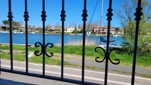 A view of a river with boats, a grassy area, and buildings in the background. - Villa-type ground floor apartment with spacious private terrace - sleeps 4 (Agde)