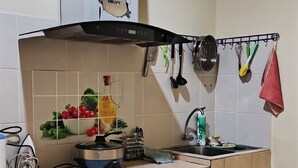 Une cuisine compacte équipée d’une cuisinière intégrée, d’un évier et d’une petite fenêtre.