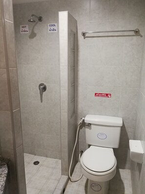 A bathroom with a shower, toilet, and a sign indicating hot and cool water. - C-Za Hotel (Hat Yai)