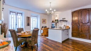 Un'ampia cucina con isola centrale, mobili in legno e un'imponente porta in legno.