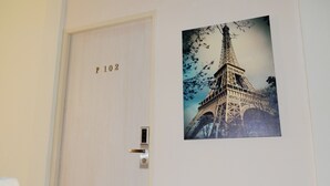 Une porte avec une plaque portant le numéro « P 102 » et, sur le mur, un tableau encadré représentant la Tour Eiffel.