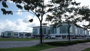 Un bâtiment moderne doté de grandes fenêtres et d’un parking.