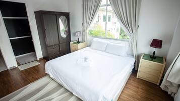 A bedroom with a large bed, a wardrobe, a nightstand, and a window with curtains.