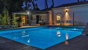 A swimming pool with a covered area, stone walls, and outdoor seating. - Contemporary villa and relaxation areas (Le Beausset)