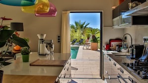 A modern kitchen with a view of a pool and outdoor seating. - Contemporary villa and relaxation areas (Le Beausset)