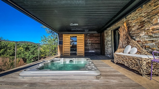 A modern outdoor hot tub area with a stone wall and wooden deck. - Contemporary villa and relaxation areas (Le Beausset)