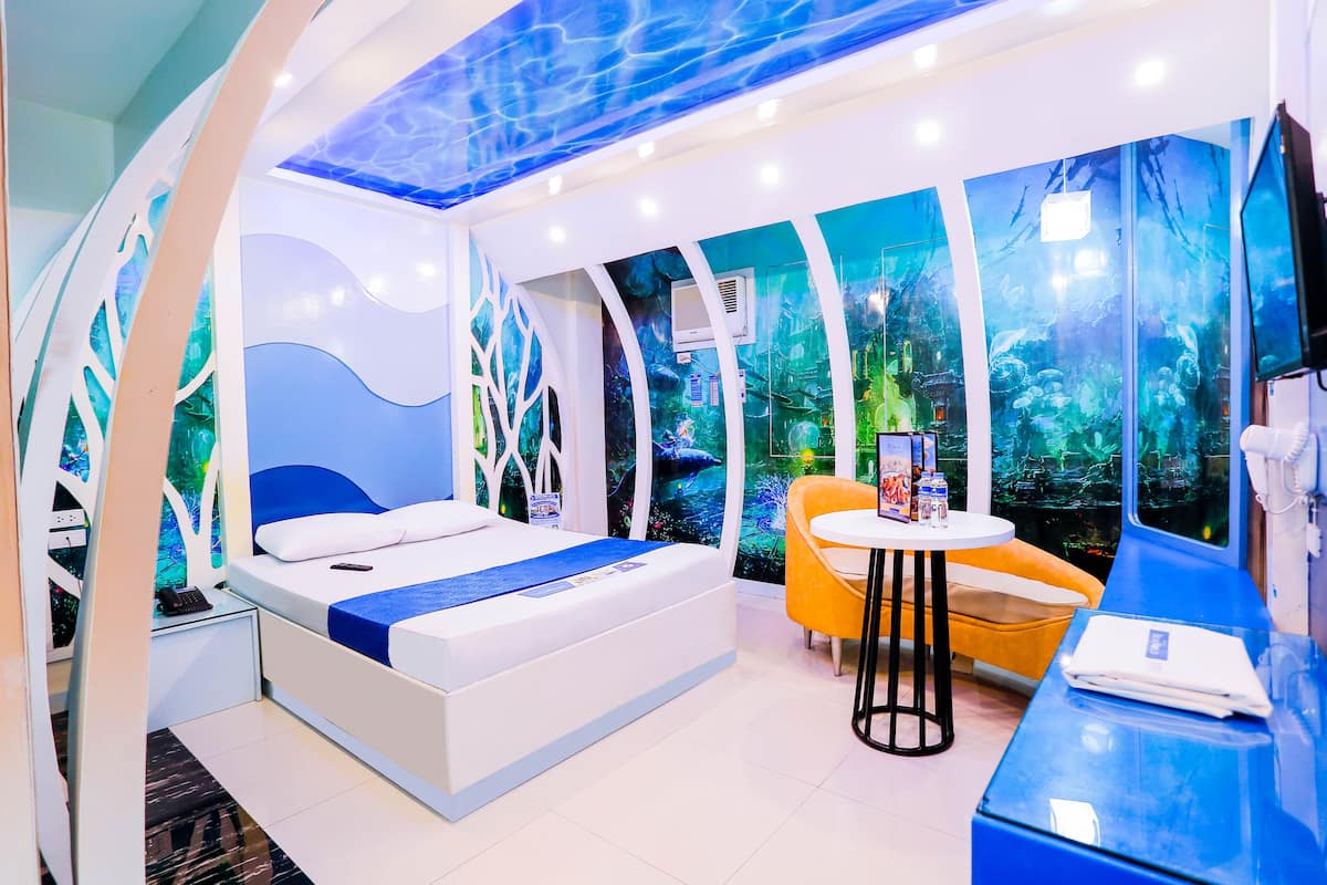 A modern hotel room with a bed, a small table, and a chair.