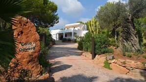 A pathway leading to a white building with a sign reading "Casa Olivera." - Villa with pool and barbecue near the beach (Ibiza)