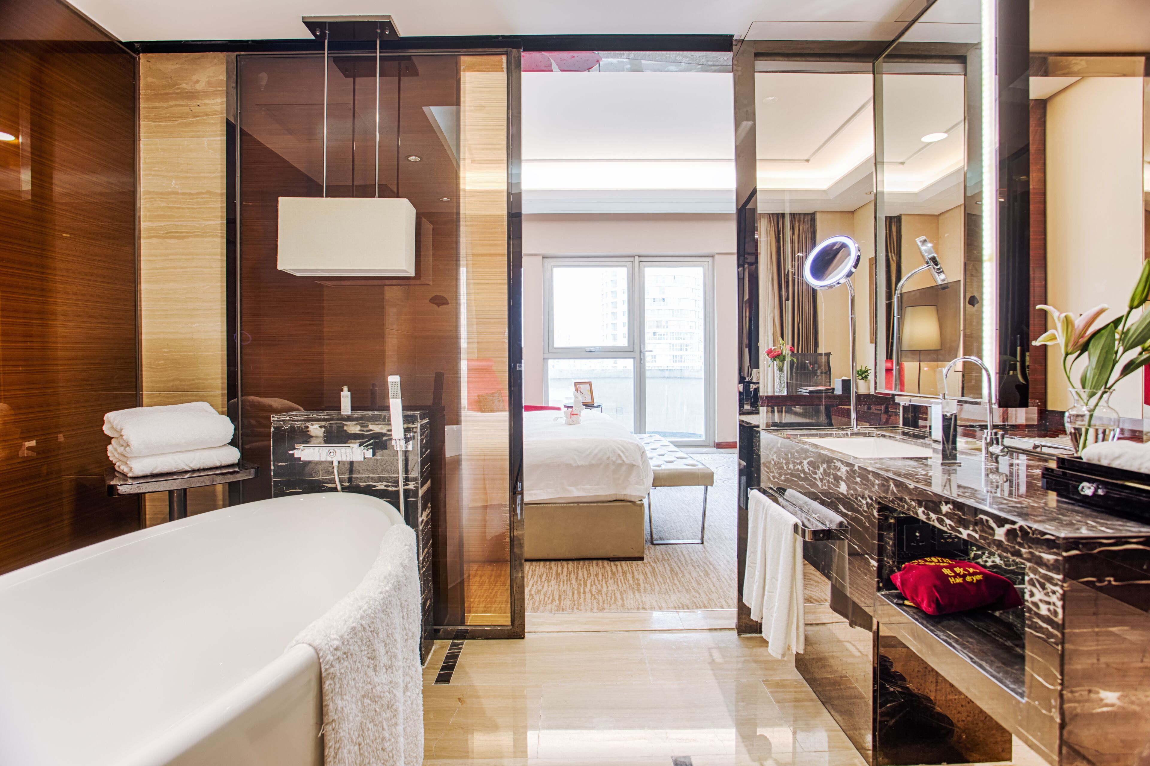 A modern bathroom with a large bathtub, a vanity with a mirror, and a separate shower area.