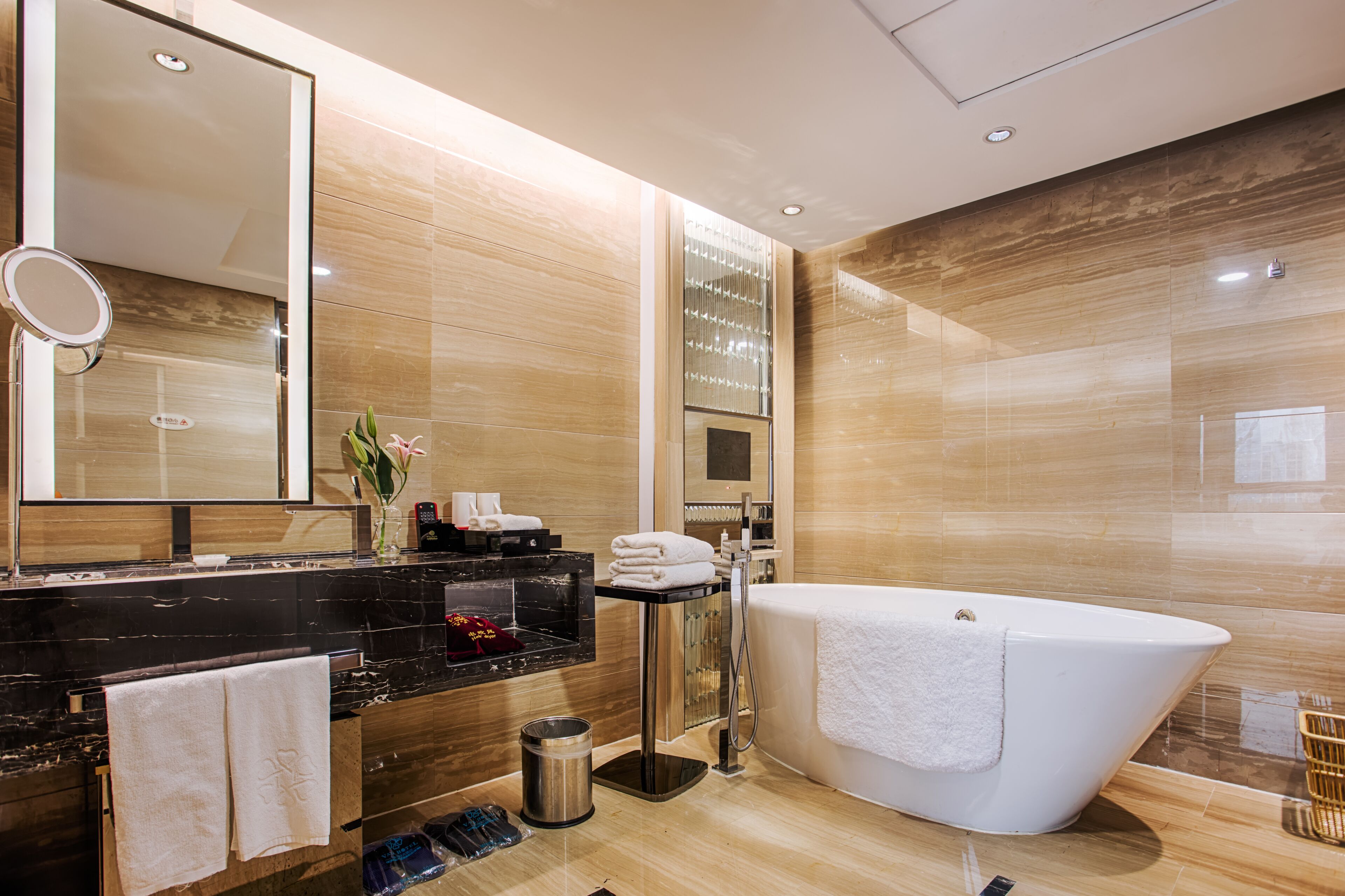 A modern bathroom with a large bathtub, a vanity with a mirror, and a toilet.