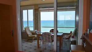 A room with a balcony, a bed, a table with chairs, and a view of the sea. - Roca Bajondillo magnificent sea views, two bedrooms, parking, free wifi (Torremolinos)