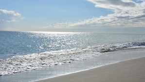 A beach with a clear sky and sunlight reflecting on the water. - Roca Bajondillo magnificent sea views, two bedrooms, parking, free wifi (Torremolinos)