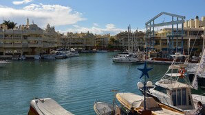 A marina with boats docked, a clear sky, and buildings with balconies. - Roca Bajondillo magnificent sea views, two bedrooms, parking, free wifi (Torremolinos)