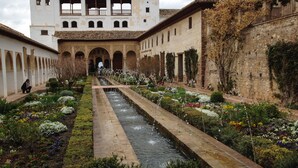 A courtyard with a central water feature, surrounded by a variety of colorful flowers and plants. - Roca Bajondillo magnificent sea views, two bedrooms, parking, free wifi (Torremolinos)