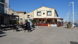 Een restaurant aan het water, genaamd "La Taverne du Port", met terras en uitzicht op het water.