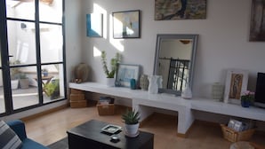 Een moderne woonkamer met een bank, salontafel en een groot raam.