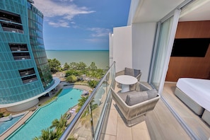A balcony with a view of a swimming pool and a building with a blue facade. - Crystalbrook Riley (Cairns)