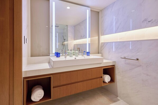 Une salle de bain moderne avec un grand miroir, deux lavabos et un porte-serviettes.