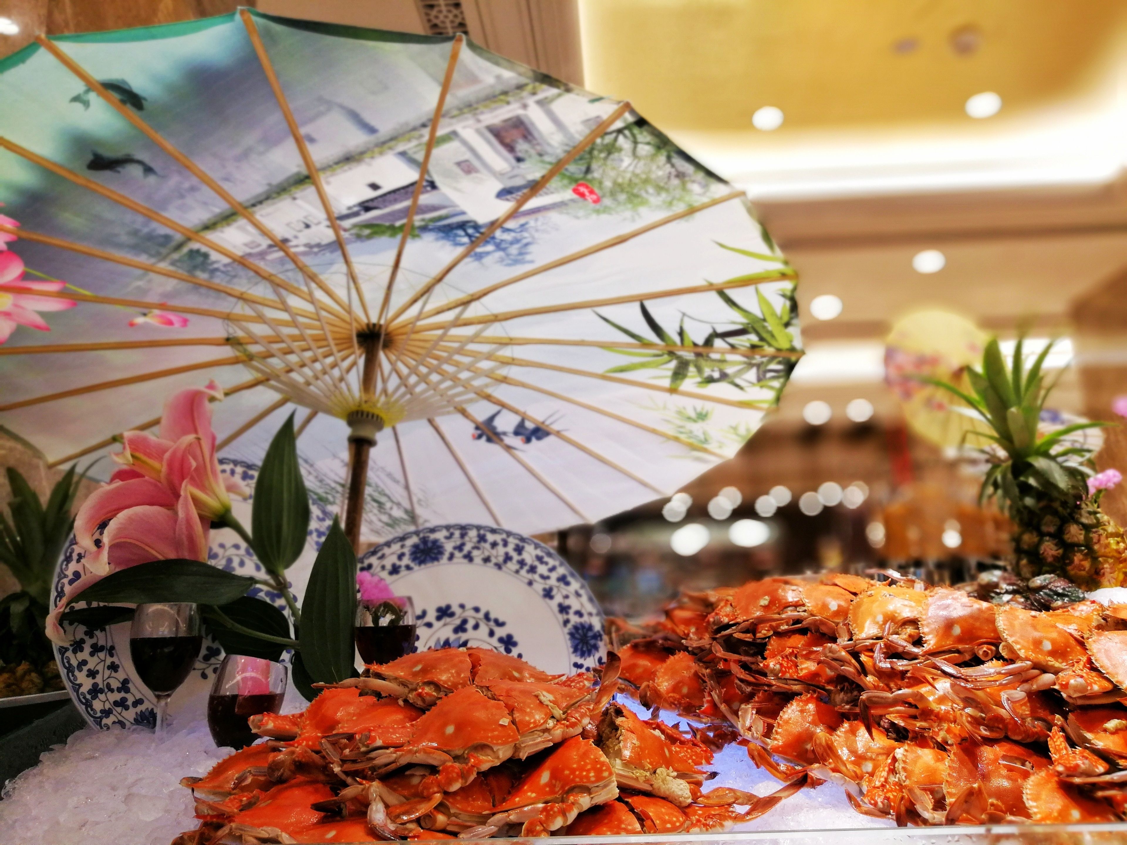 A seafood display with crabs, a decorative umbrella, and a floral arrangement.