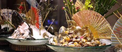 Une présentation de fruits de mer agrémentée de décorations, notamment des éventails et des fleurs.