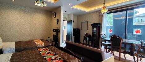 Habitación de hotel con una cama grande, un sofá, una mesa de comedor con sillas y vistas al exterior.