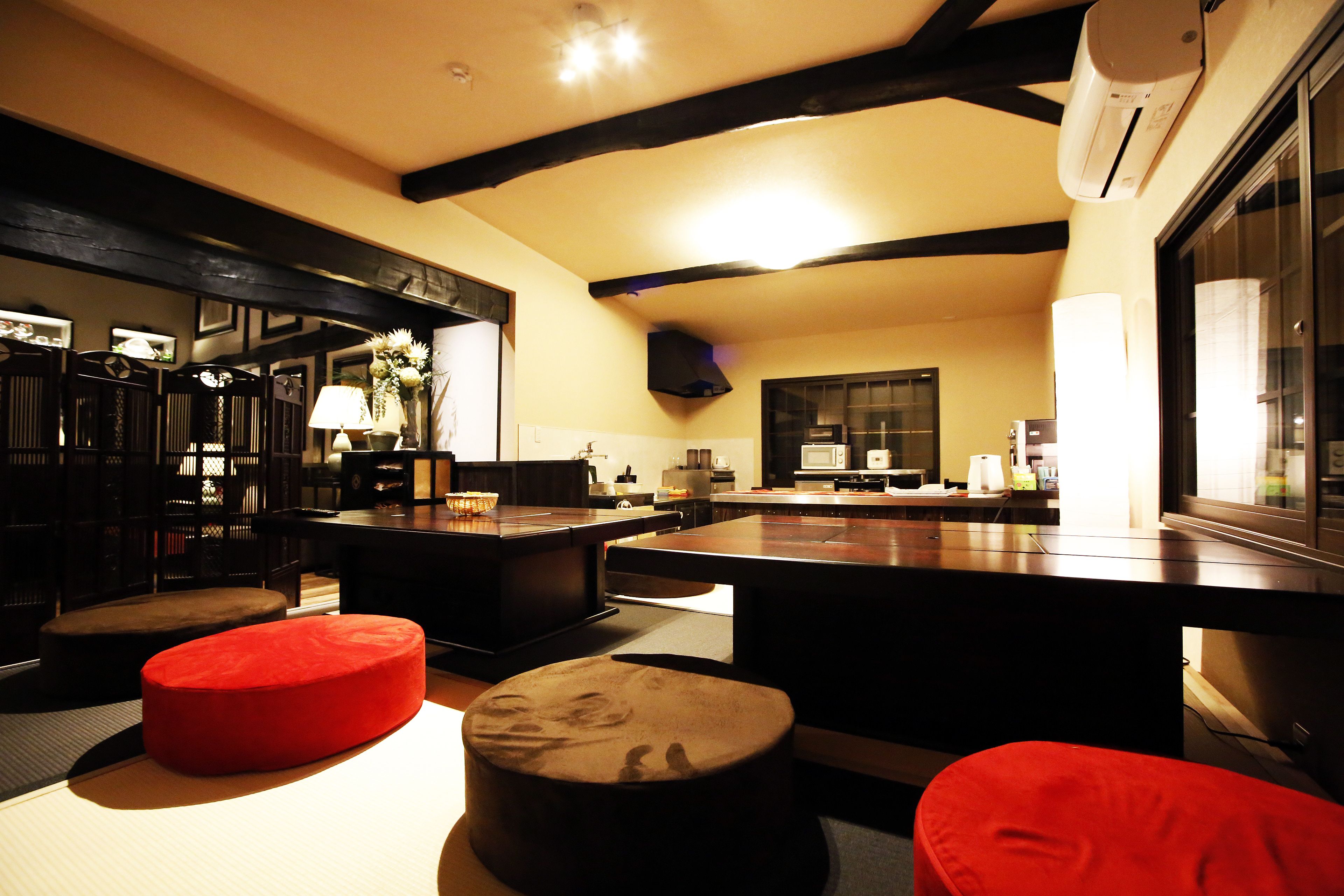 A modern kitchen with dark wooden accents, a central island, and red seating.